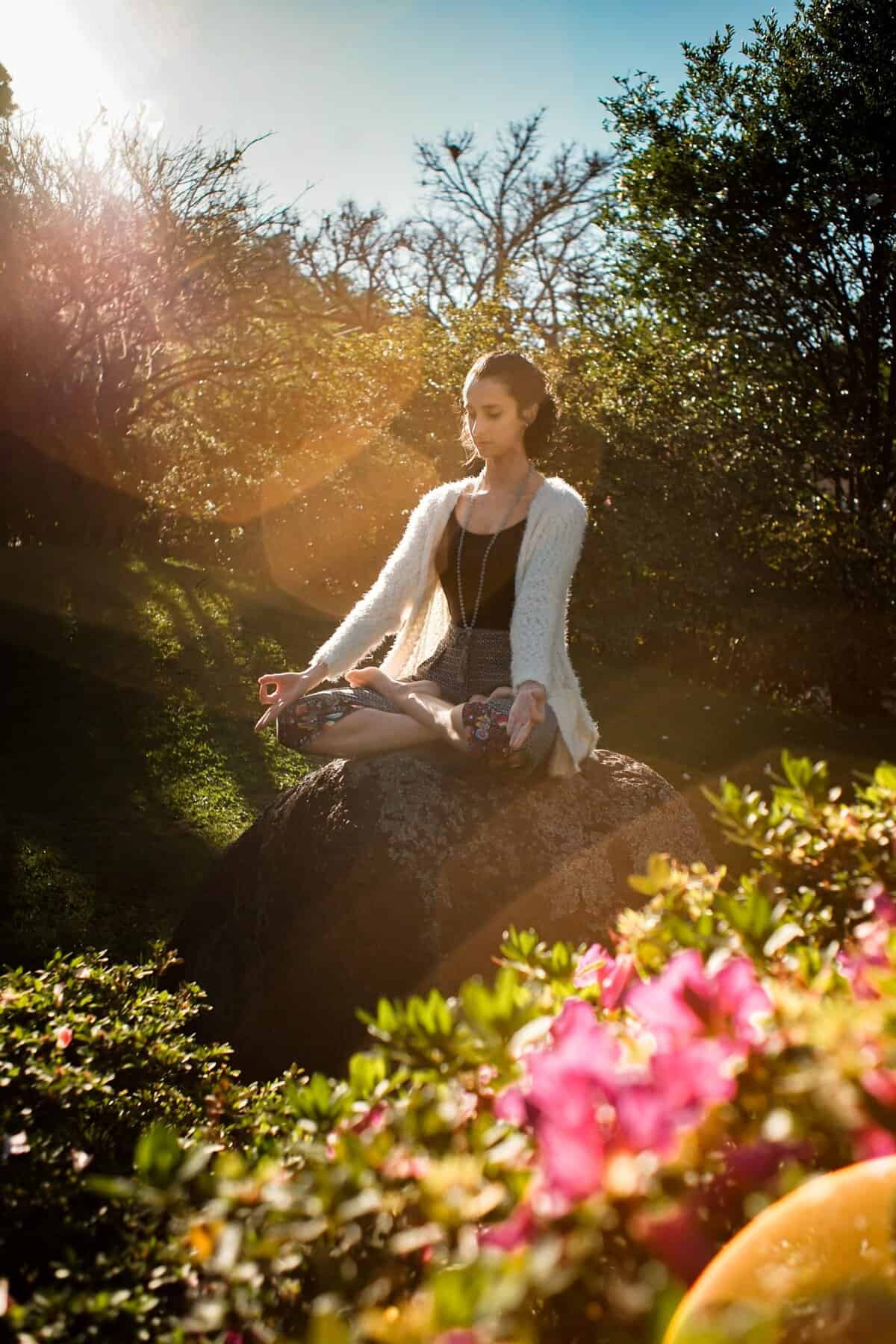 Woman Mediating with lotus Peaceful meditation in practical mysticism with divine golden light streaming through trees"
