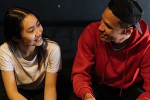 Two people smiling warmly at each other in close proximity, representing mutual devotion and reciprocal divine love